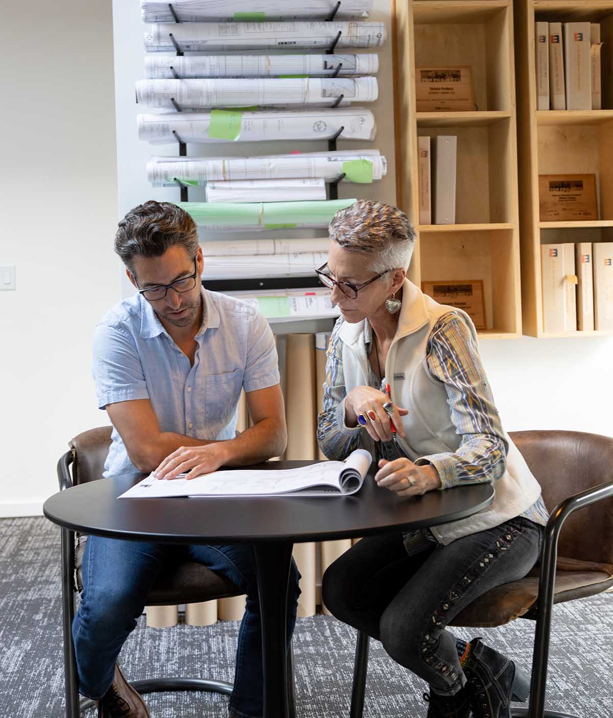 Man and woman at table reviewing building plans